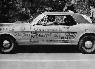 Férfi mosolyog a Ford Mustangjában, amire háborúellenes szövegek vannak írva - Forrás: Getty Images/© Hulton-Deutsch Collection/CORBIS/Corbis 